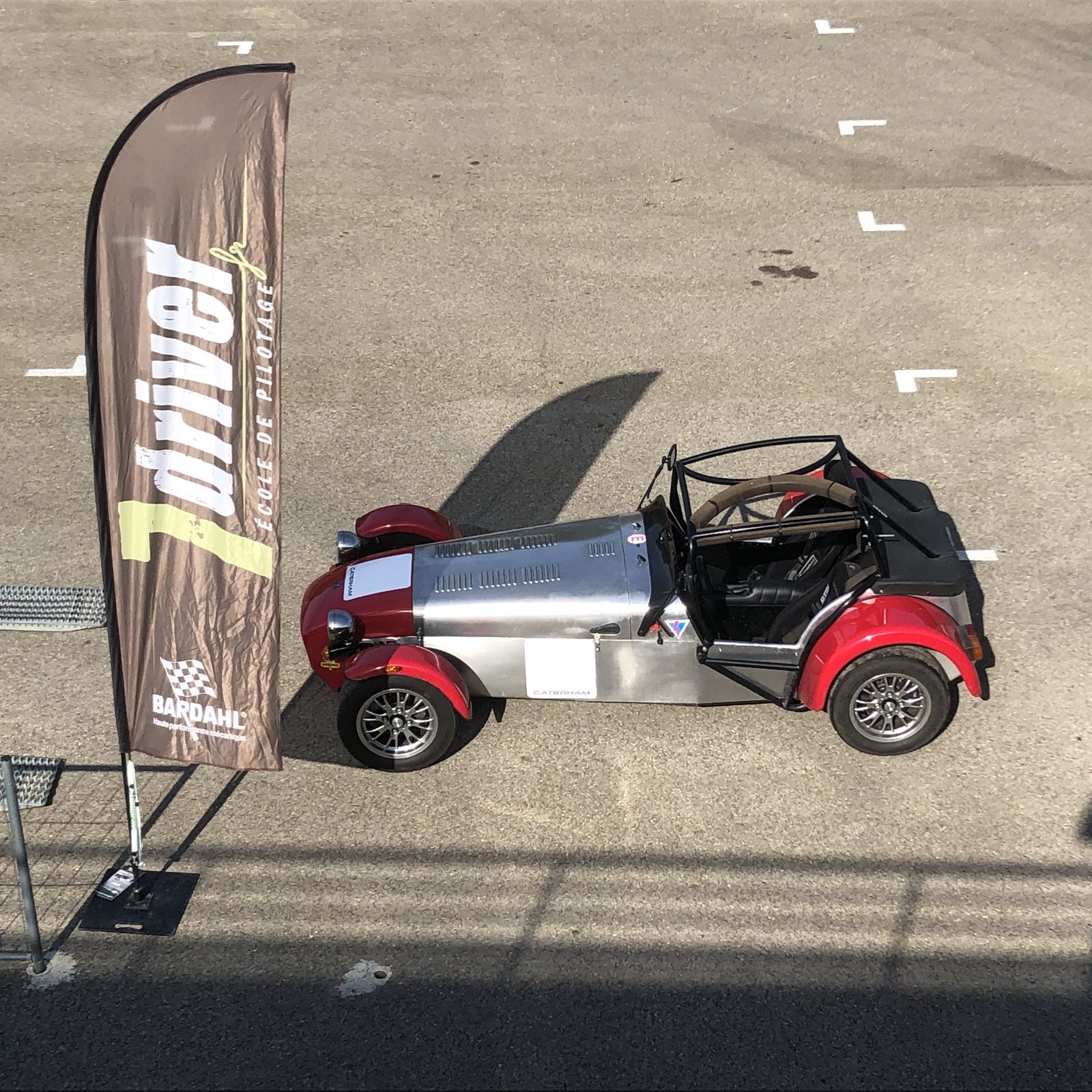 Caterham 7'Driver devant l'oriflamme de l'école