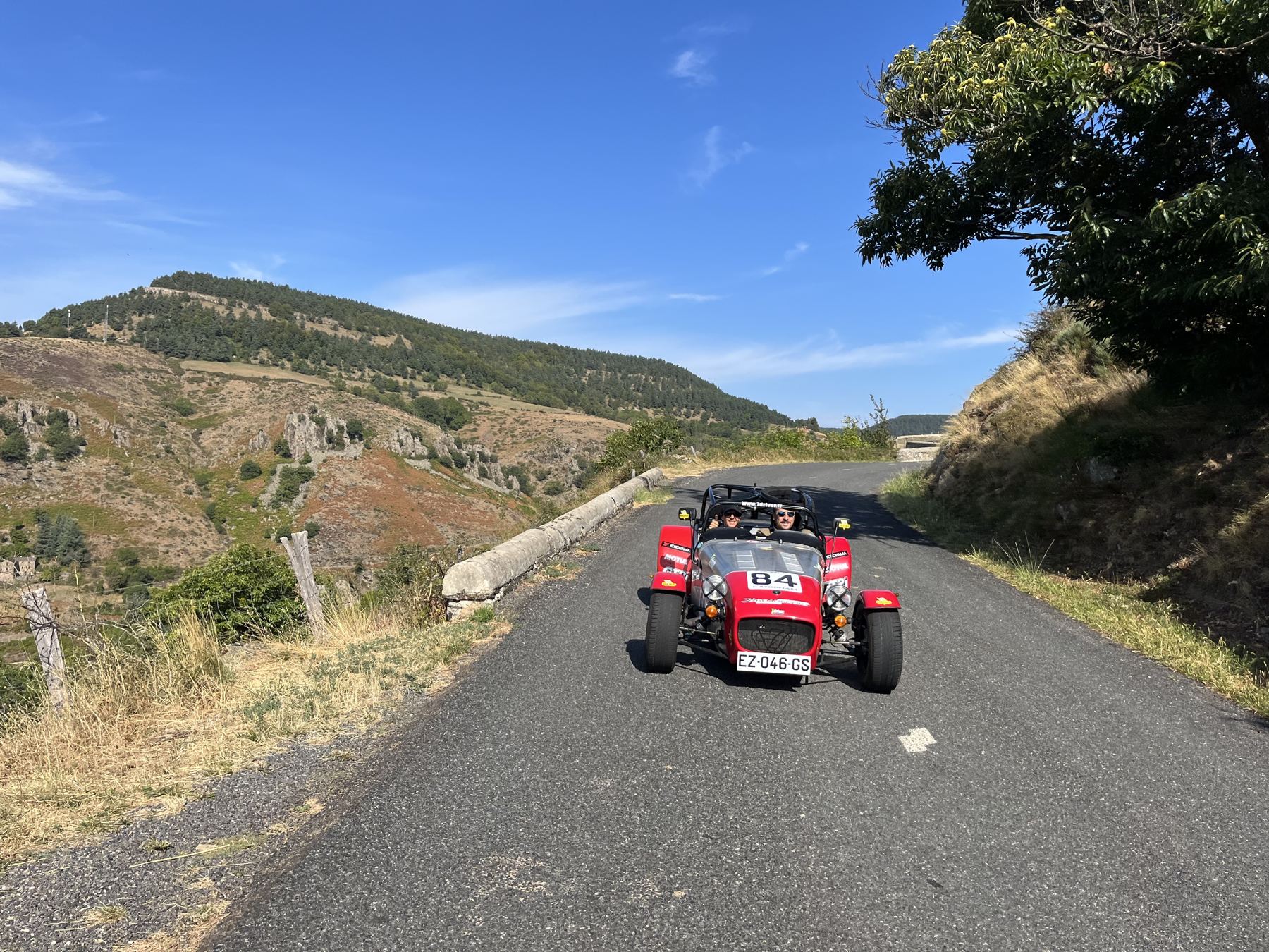 Caterham sur une route des Cévennes, montagne en fond